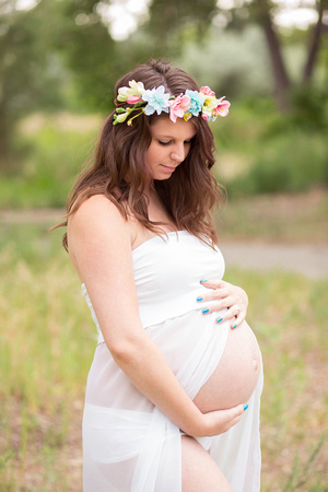 Maternity photo of pregnant mom in a sheer dress and flower crown.