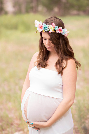 Maternity photograph of mom to be in sheer gown and flower crown.